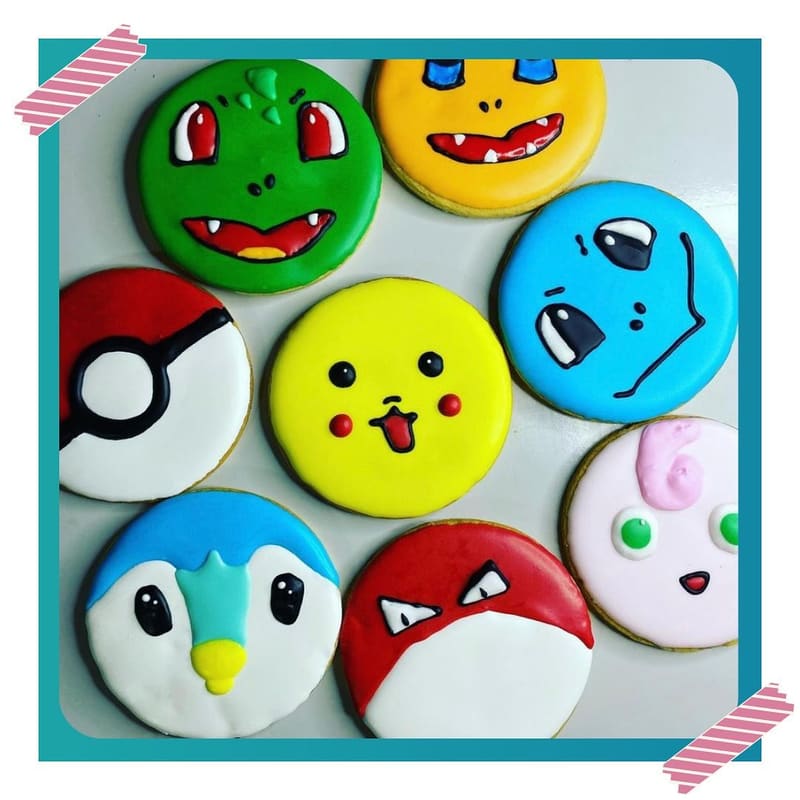 Bandeja com biscoitos redondos decorados com rostos de personagens em cores vibrantes